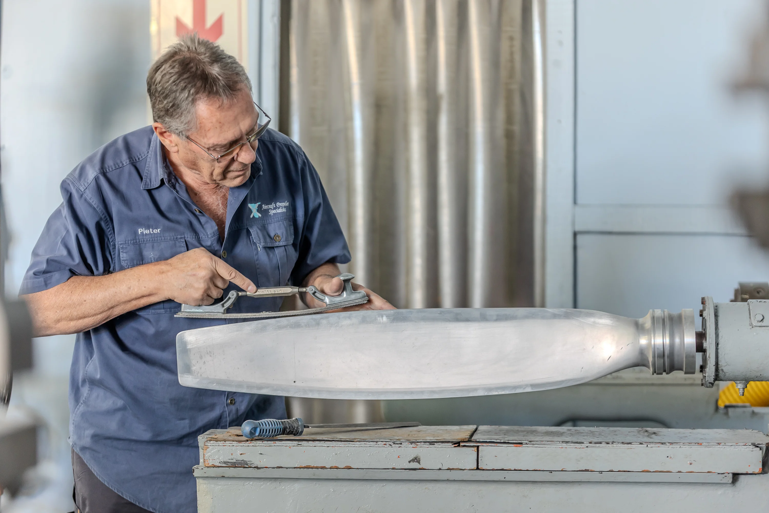 Specialist working carefully on an aircraft propeller blade